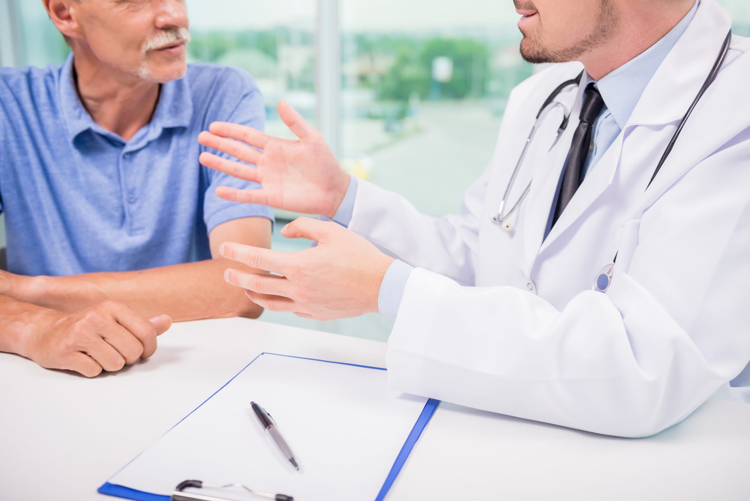 Médico explicando un reporte de biopsia de piel a un paciente adulto mayor