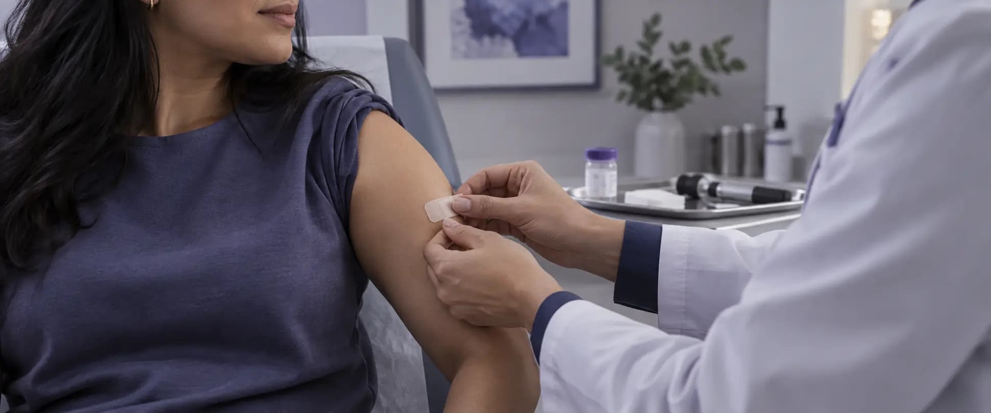 Dermatólogo colocando un pequeño apósito después de realizar una biopsia de piel en el brazo de una paciente.