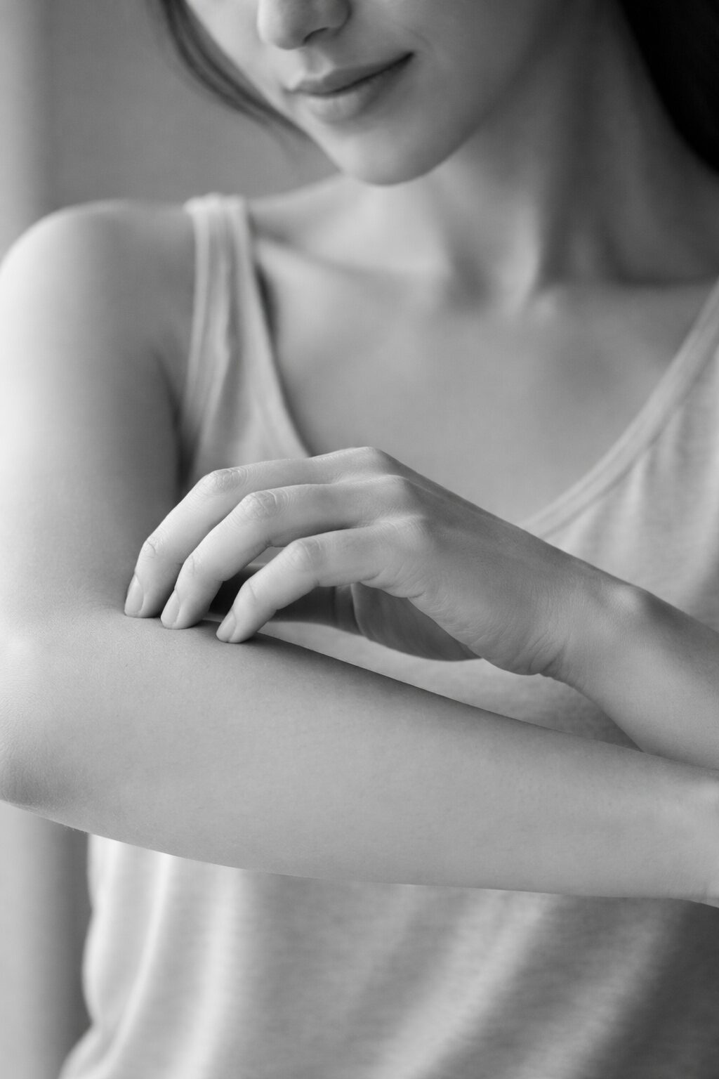 Persona rascándose suavemente el antebrazo para ilustrar el picor en la piel