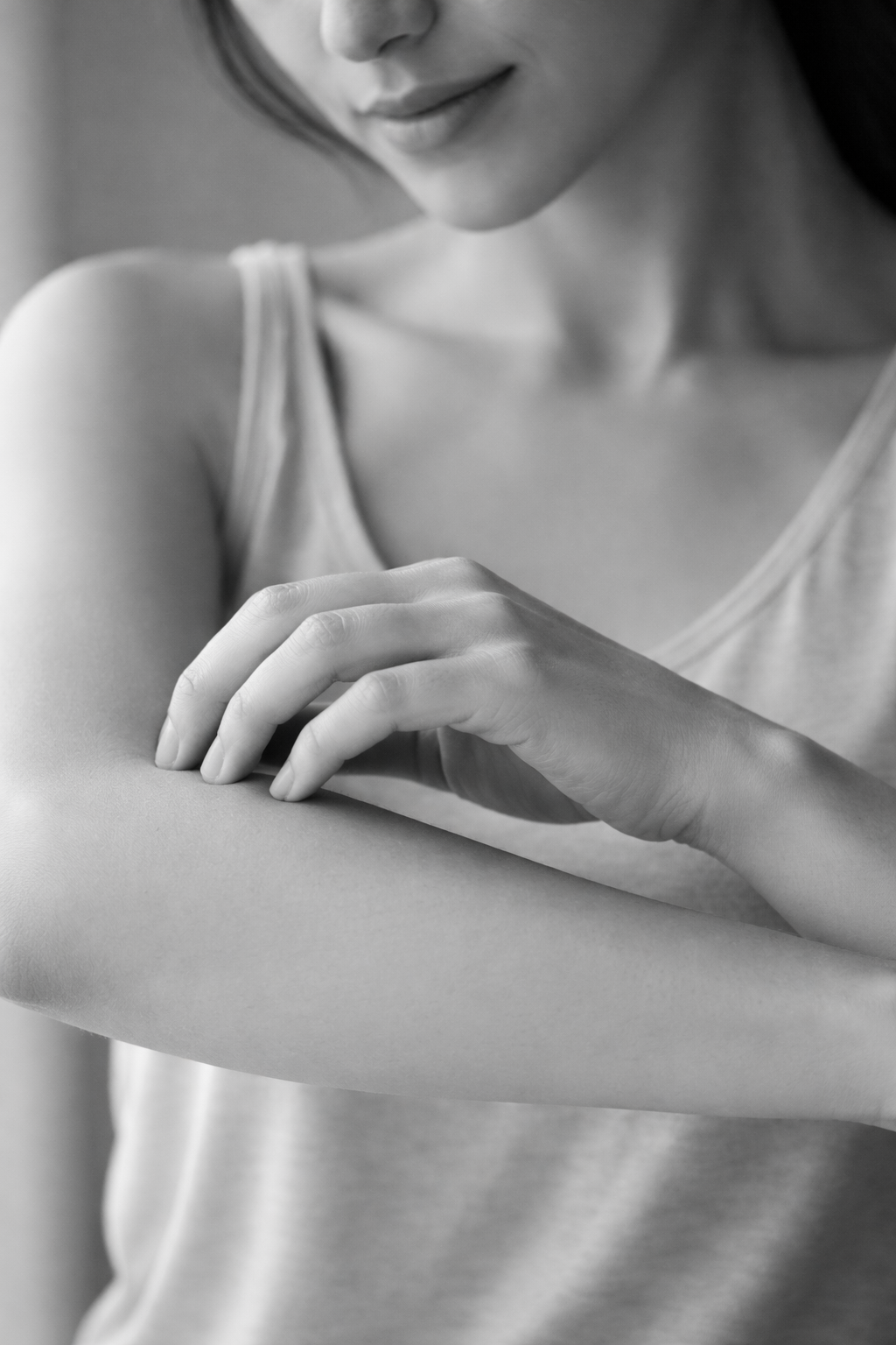 Persona rascándose suavemente el antebrazo para ilustrar el picor en la piel